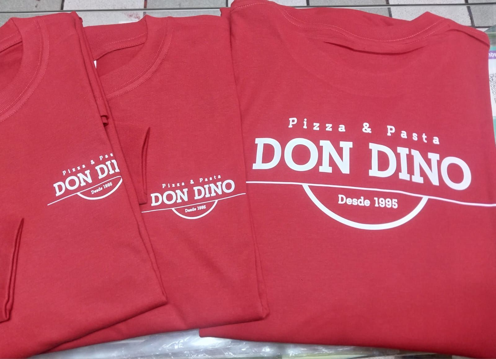 Tres camisetas rojas con el logotipo blanco 
