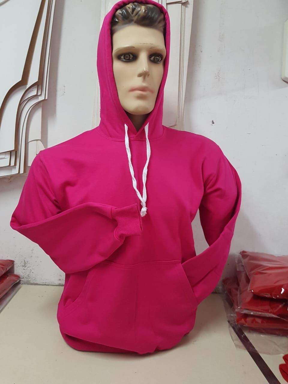 Una sudadera con capucha de color rosa brillante y cordones blancos