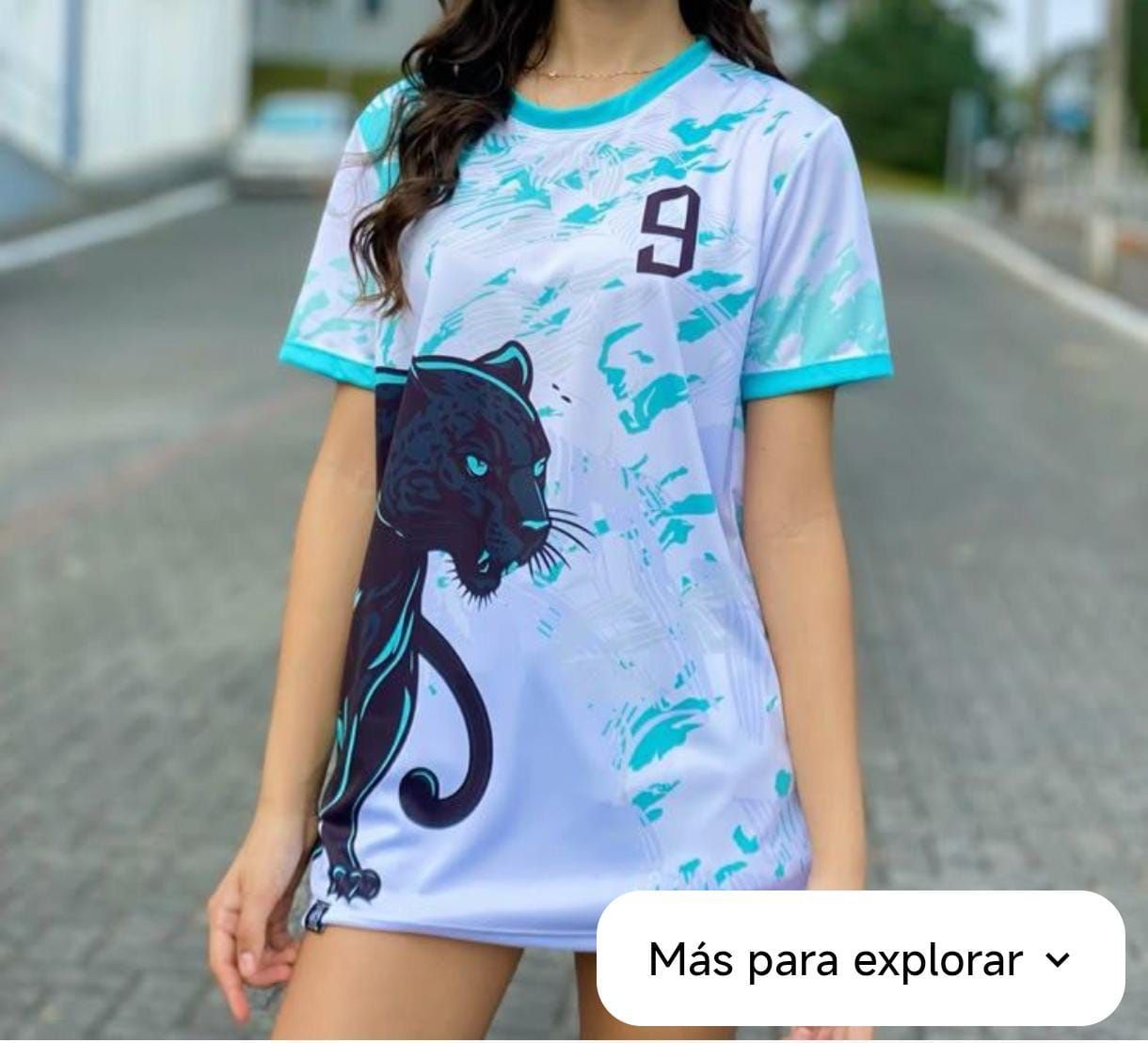 Una persona lleva una camiseta blanca con un estampado abstracto de color verde azulado