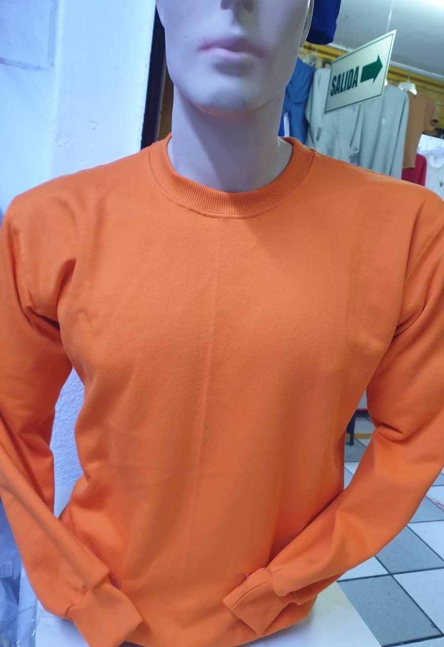 En un entorno de tienda, un torso de maniquí luce una sudadera naranja lisa de manga larga y cuello redondo.