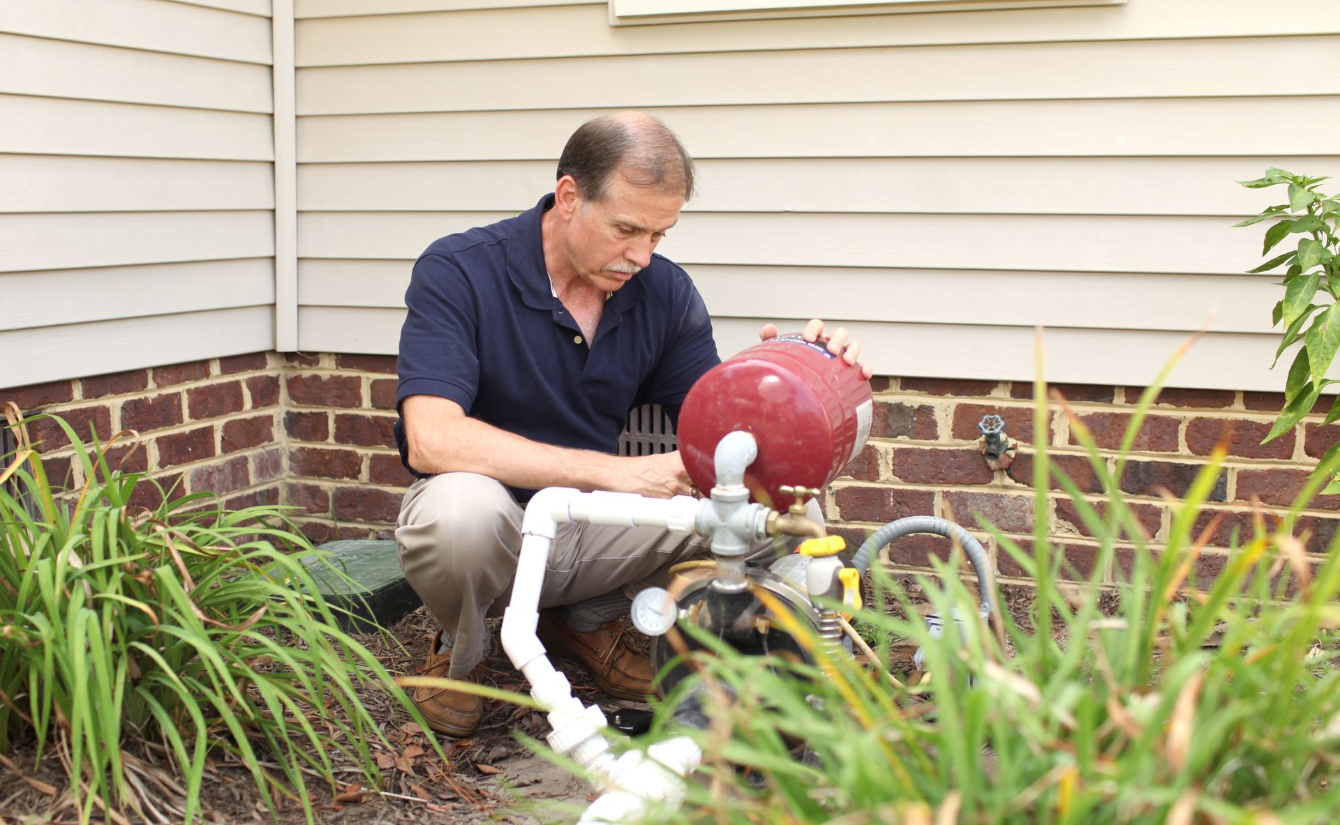 Homeowner inspecting his water pump for issues.