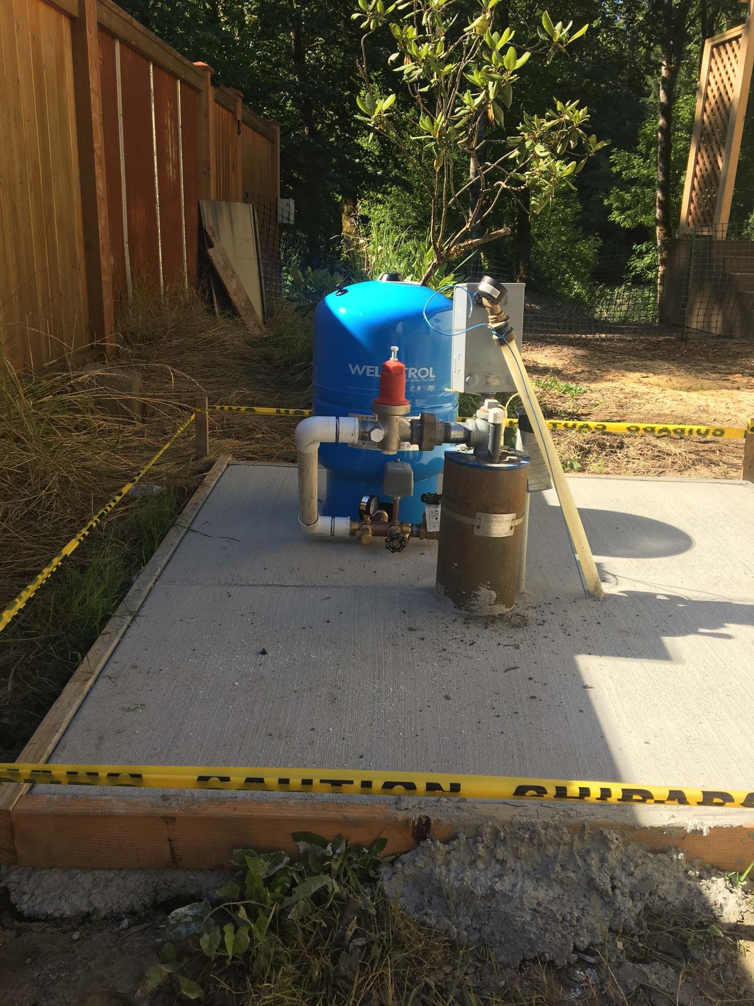 A blue tank is sitting on top of a concrete platform.