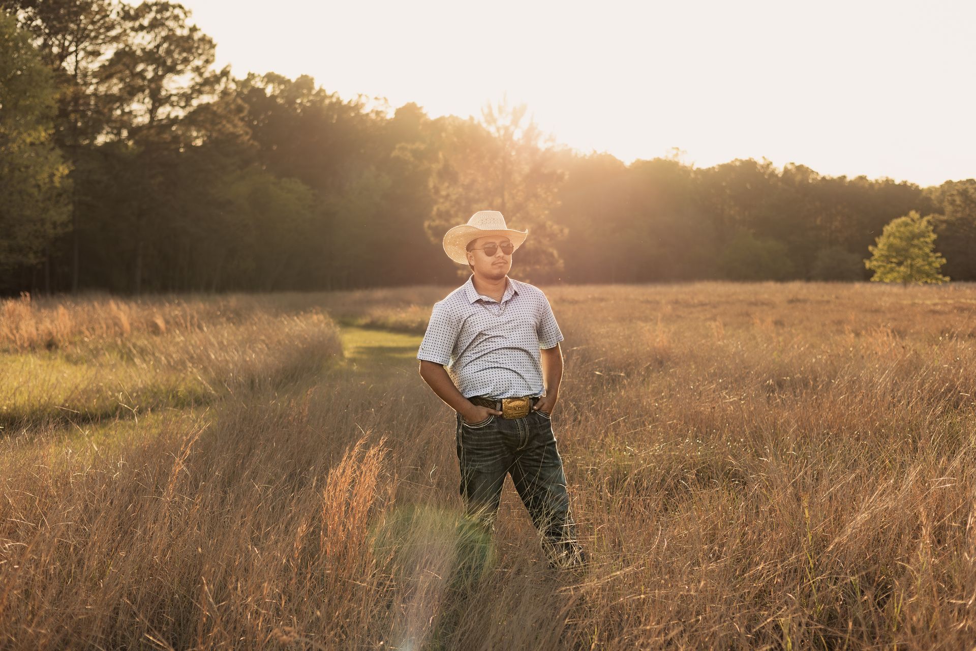 Senior boy photography in kingwood, tx with an open field at golden hour. senior boy photography poses. senior boy session senior photography