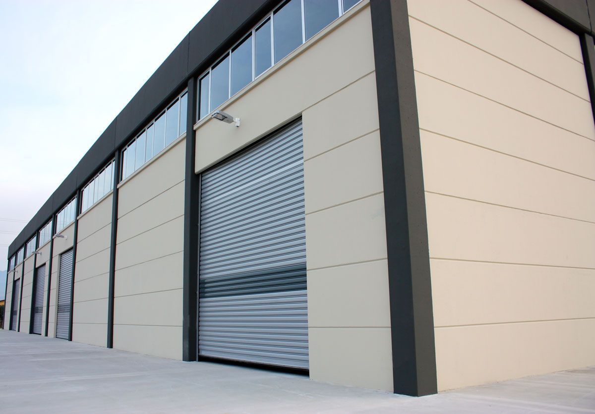 A large building with a roller shutter on the side of it