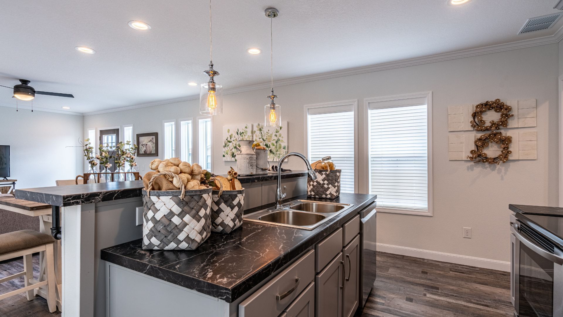Kitchen with granite countertops, pendant lights, and two baskets on an island.