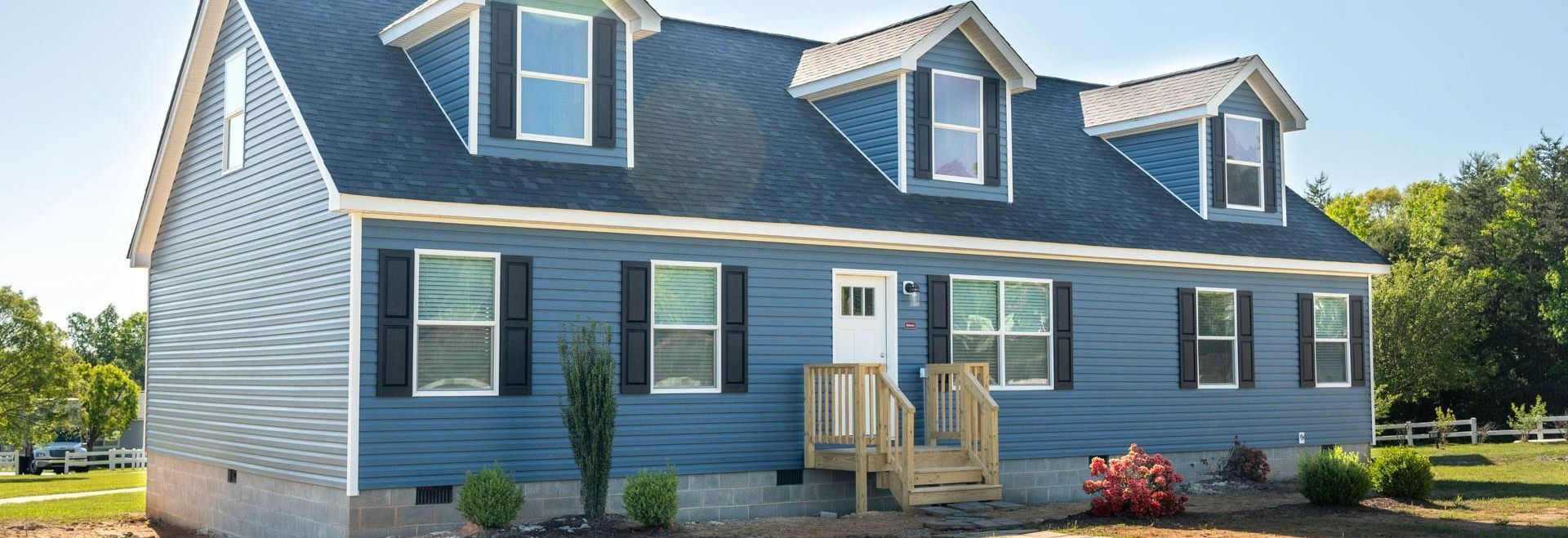 A blue and white house with a blue roof and black shutters A blue and white house with a blue roof and black shutters