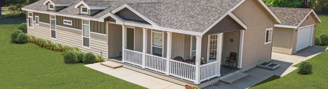 A tan house with a white porch and a garage on a green lawn.