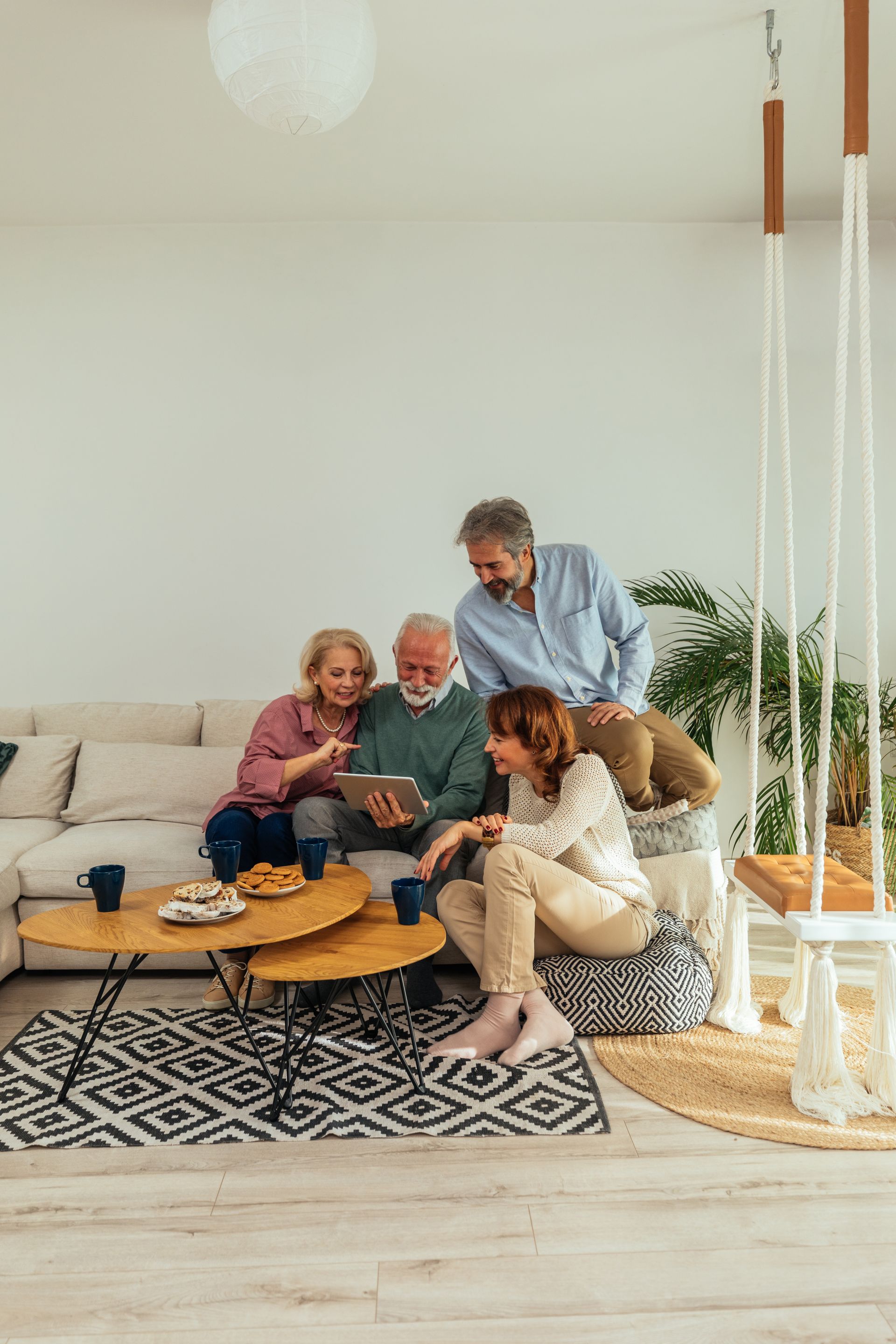Four people gathered on a sofa around a coffee table in a bright living room