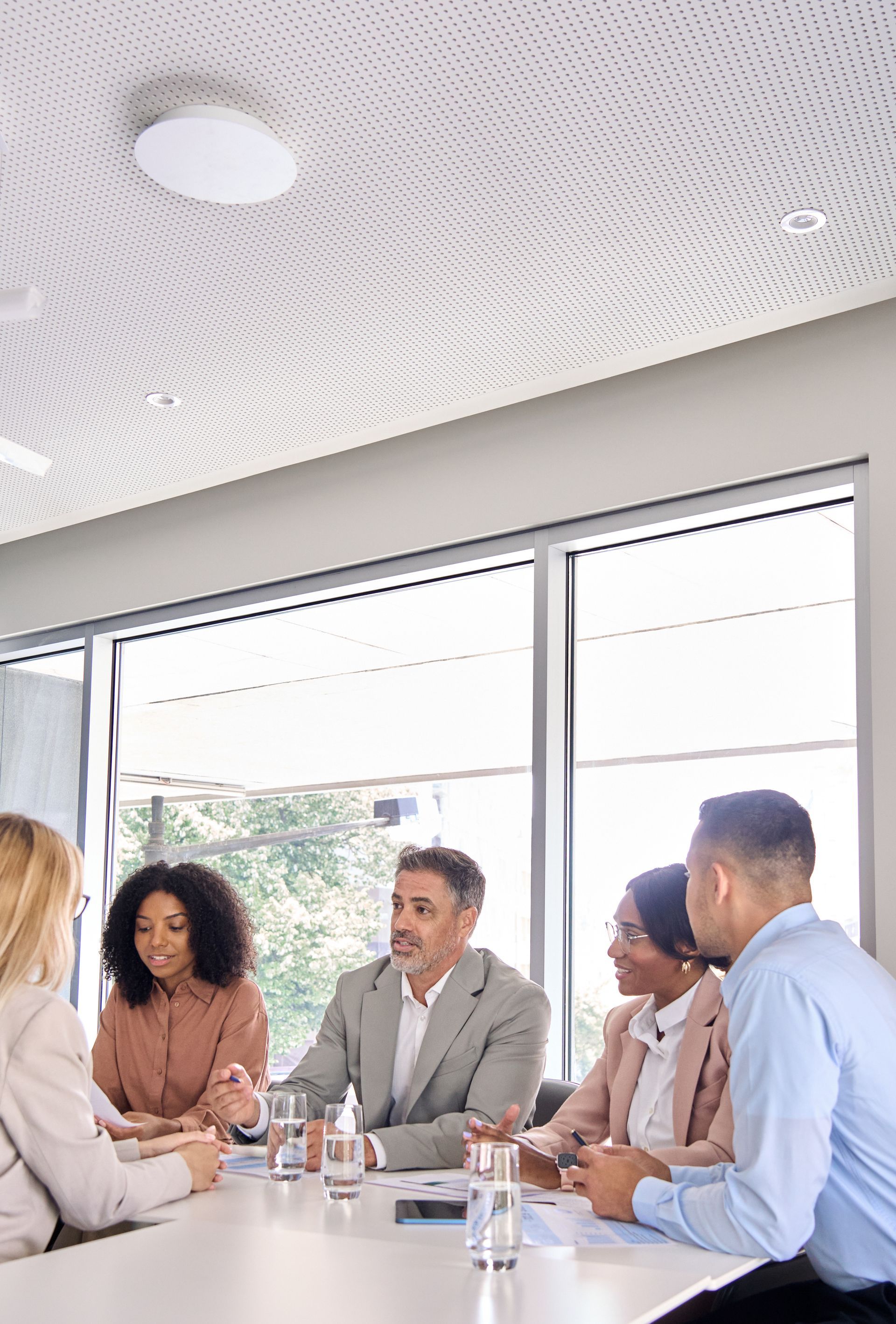 Business meeting with five people seated around a conference table in a bright office