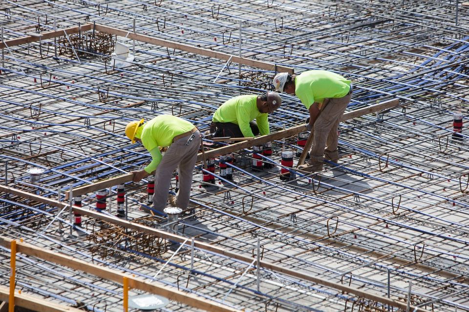 Un groupe d'ouvriers du bâtiment travaillent sur un sol en béton.