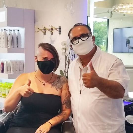 A man and a woman wearing face masks giving a thumbs up