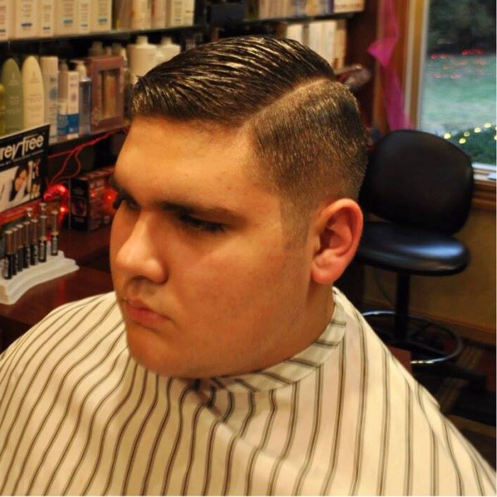 A man is getting his hair cut at a barber shop