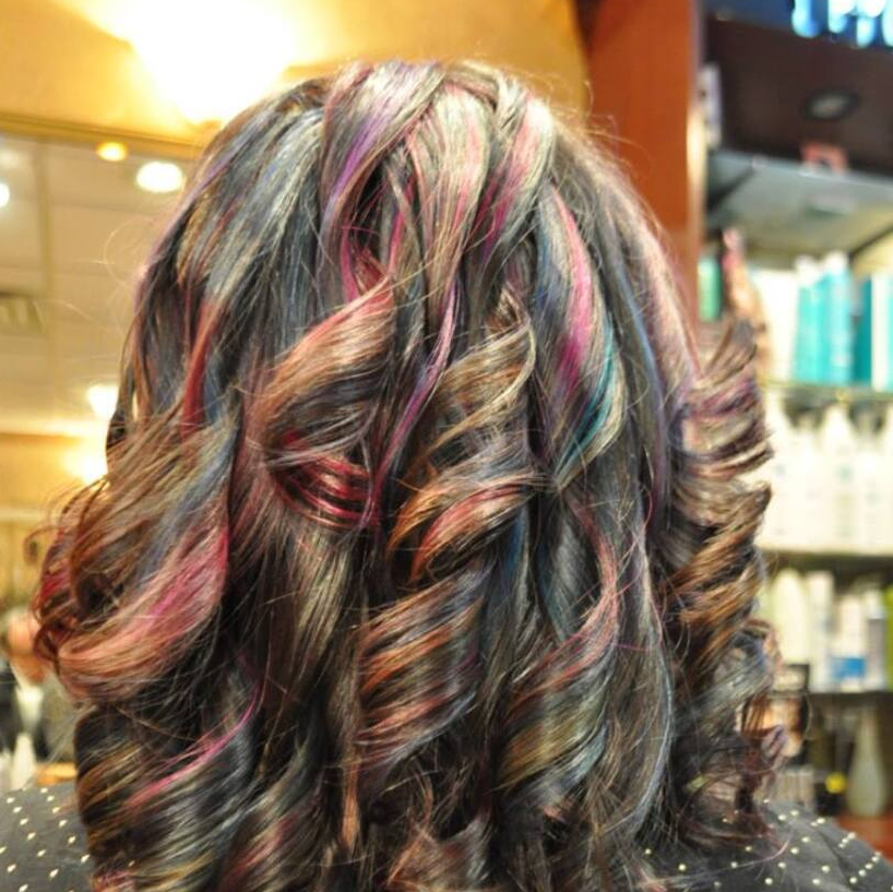The back of a woman 's head with colorful hair