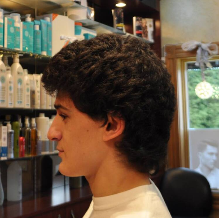 A young man is getting his hair cut in a salon
