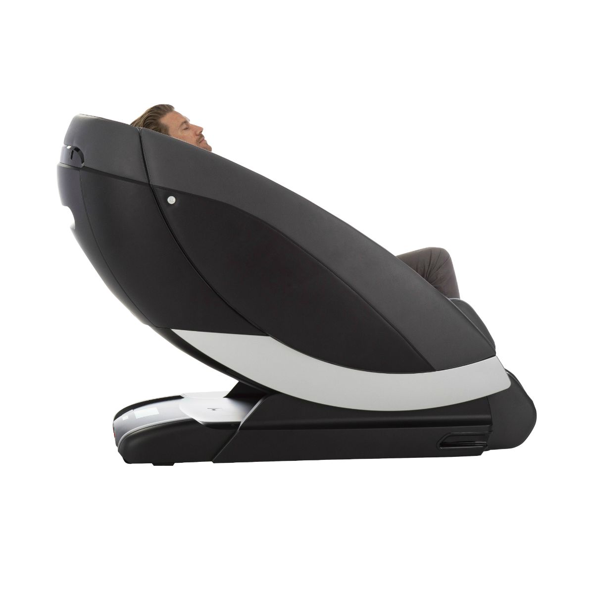 A man is sitting in a black and white massage chair.