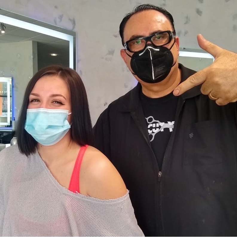 A man and a woman wearing face masks are posing for a picture