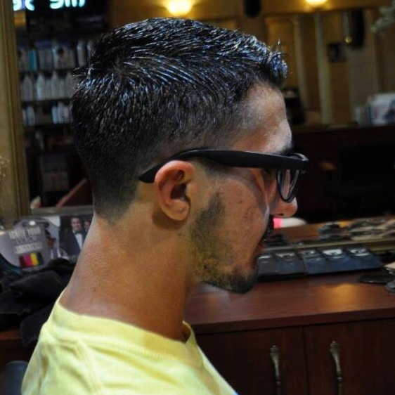A man is wearing glasses and a yellow shirt