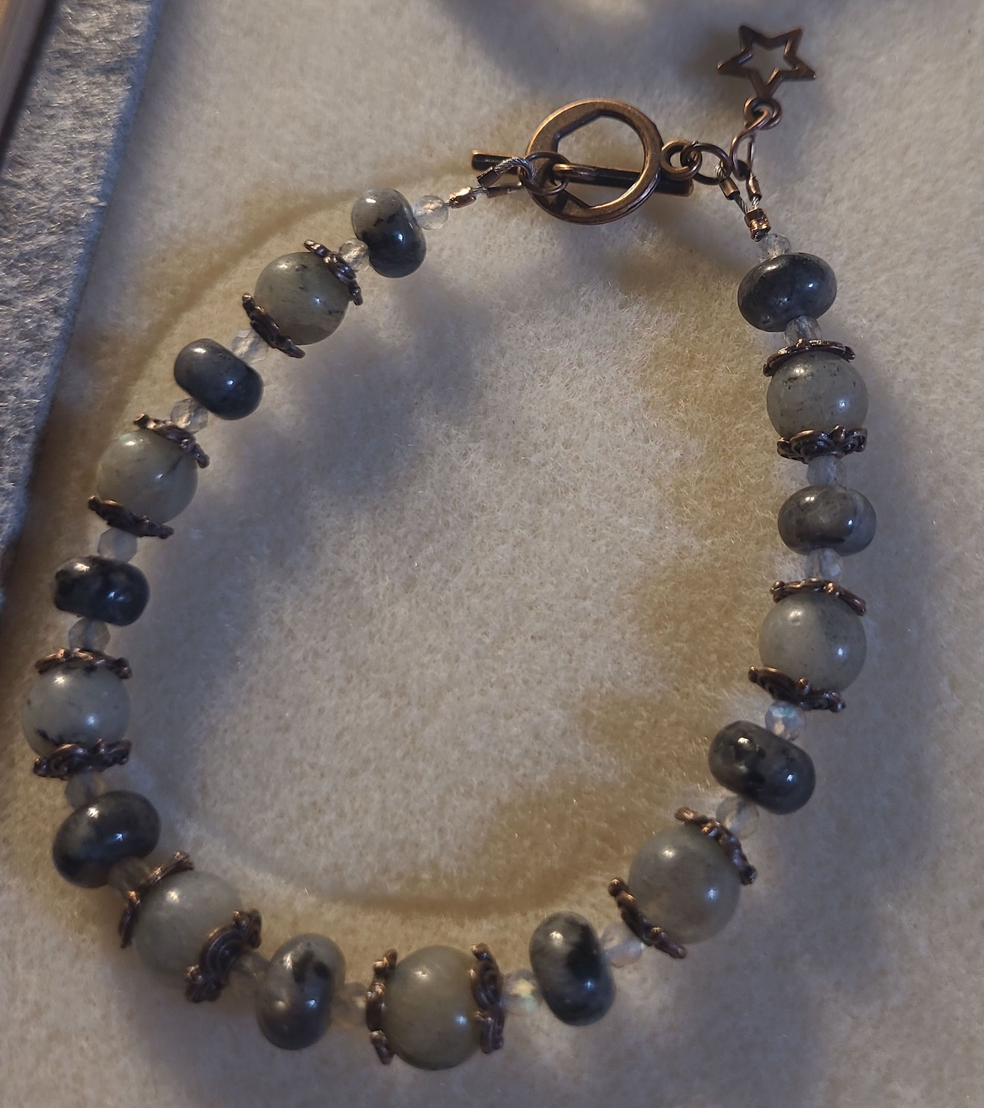 A bracelet with blue and white beads and a star shaped clasp