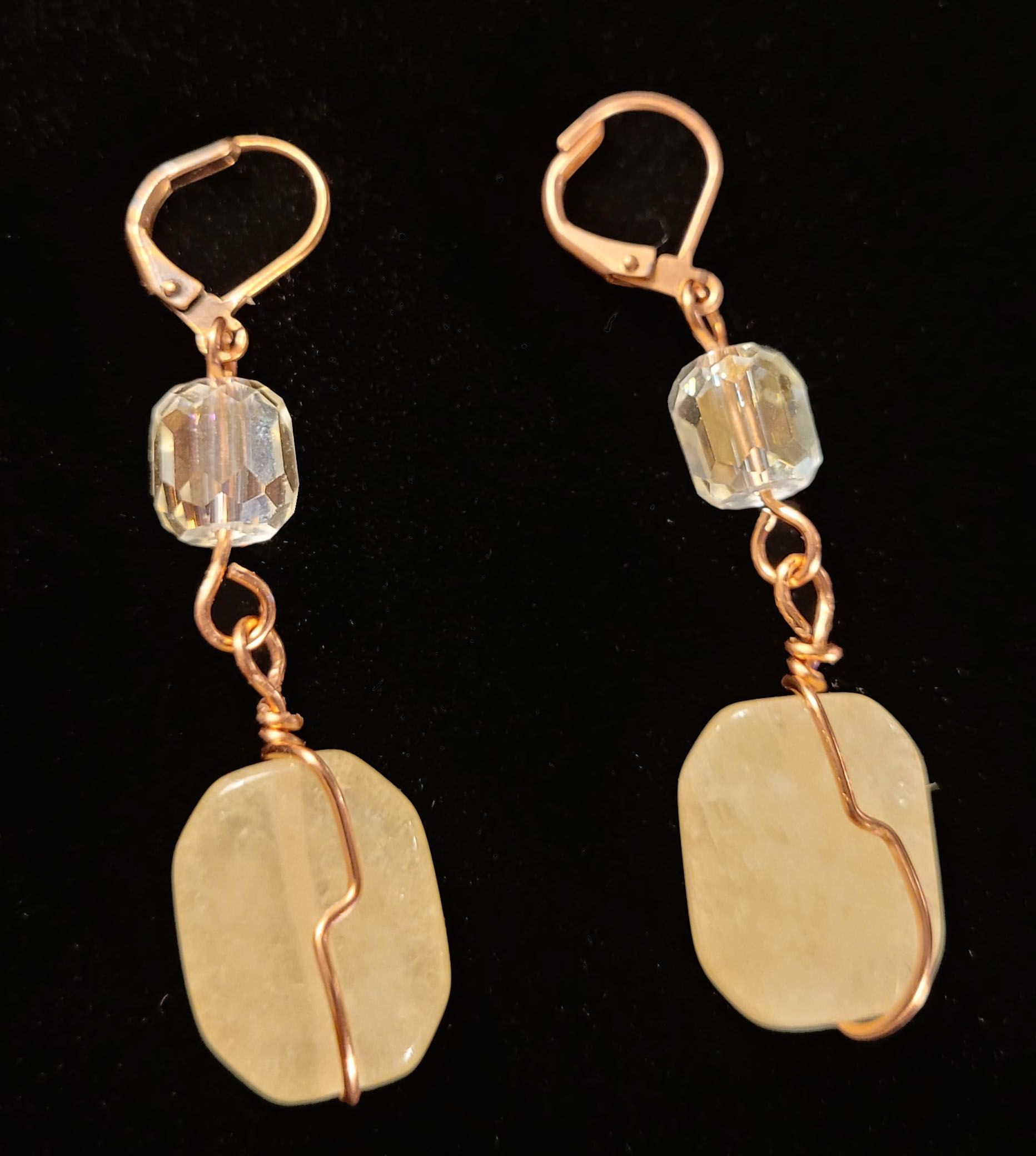 A pair of gold wire wrapped earrings with clear beads
