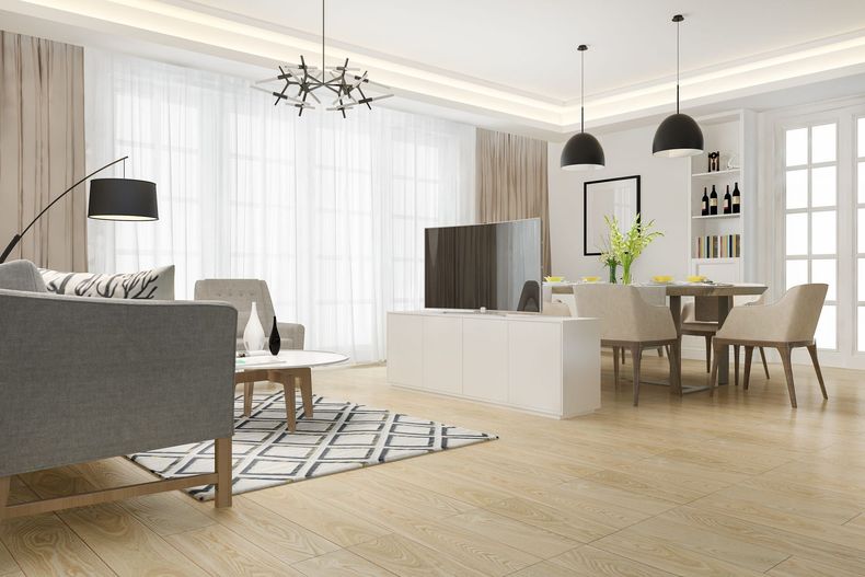 Modern kitchen and dining room with wood accents, black appliances, and a decorative mirror.