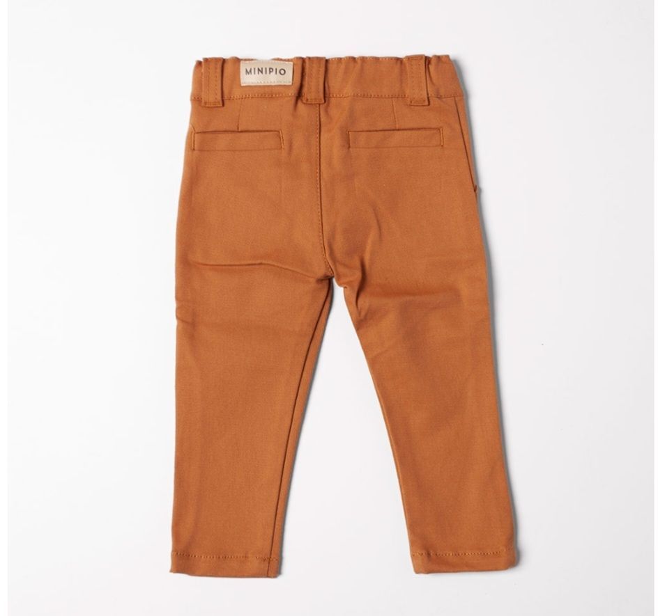 Pantalón de niño color tostado, vista trasera, con dos bolsillos y una pequeña etiqueta de marca en la cinturilla.