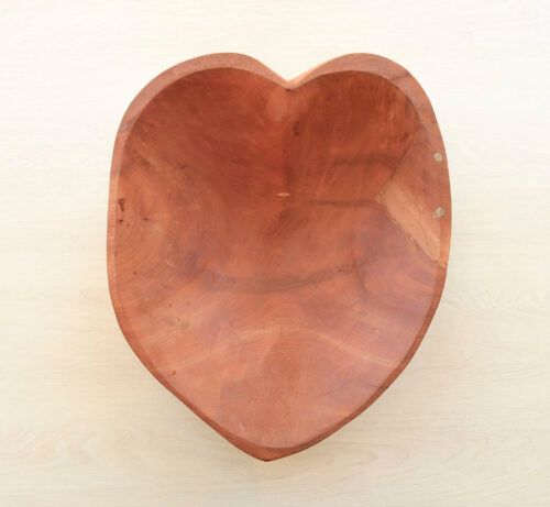 Cuenco de madera con forma de corazón sobre un fondo claro.