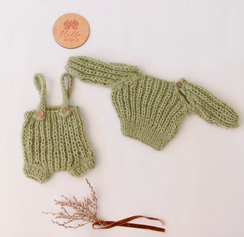 Pelele de bebé de punto verde y gorro con orejas de conejo sobre fondo blanco con una pequeña.