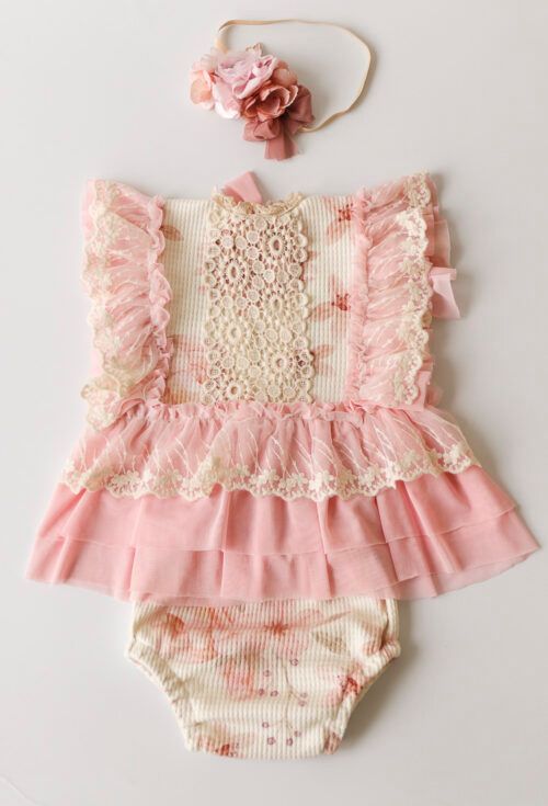 Conjunto rosa de bebé con volantes, top de encaje, falda con volantes, bombachos a juego y diadema floral.