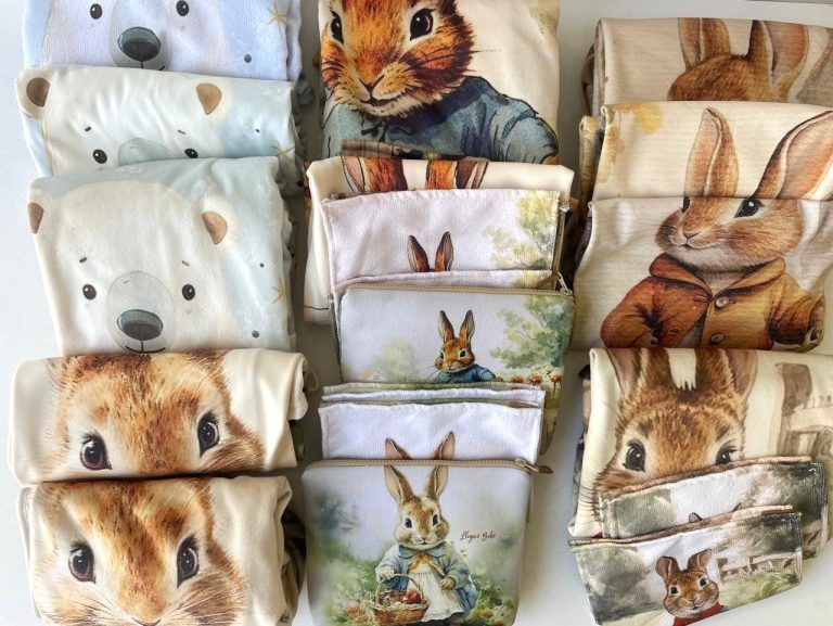 Surtido de mantas dobladas con estampados de animales: osos, conejos y otros animales del bosque.