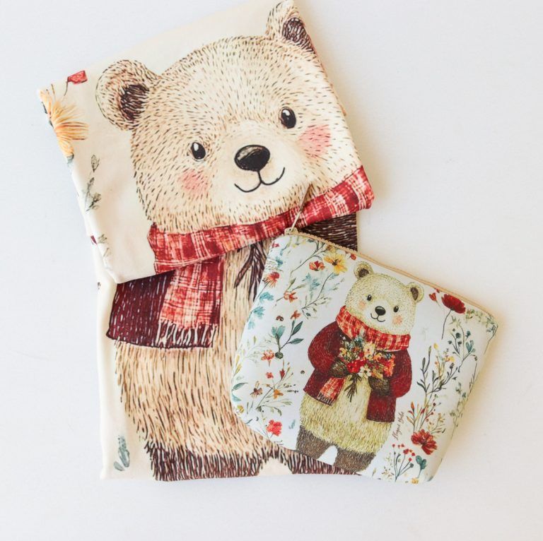 Dos bolsitas de tela con ositos de peluche con estampados florales y bufandas rojas.