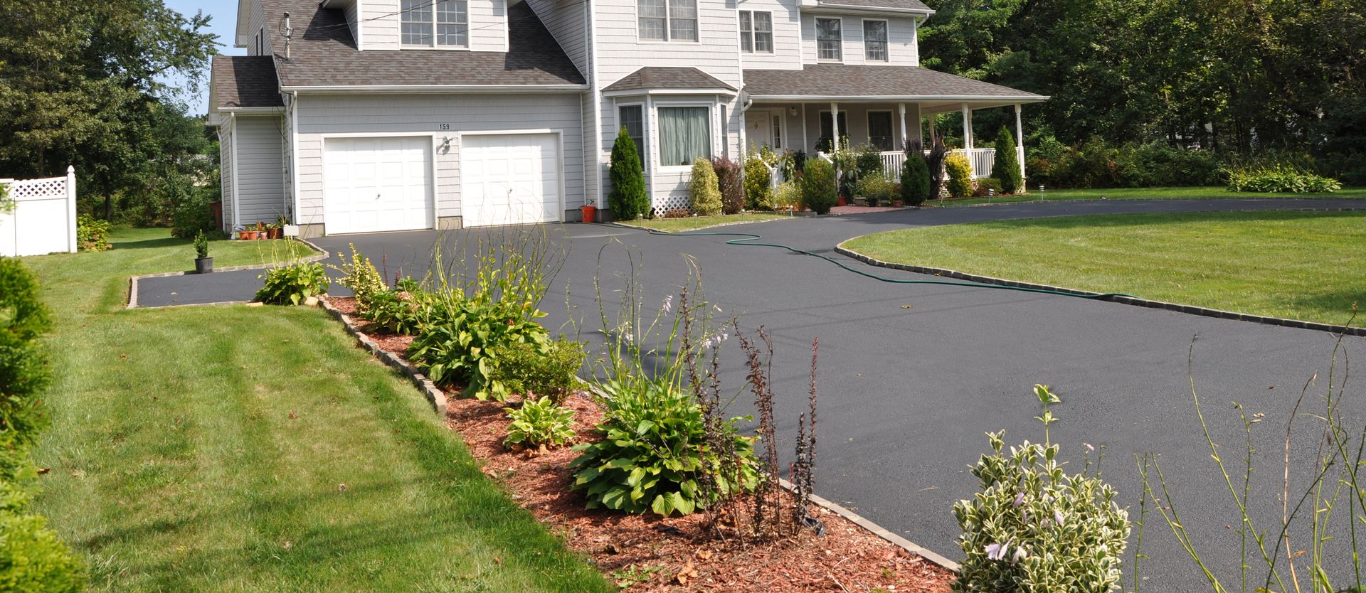 A large house with a long driveway and a well-manicured lawn.