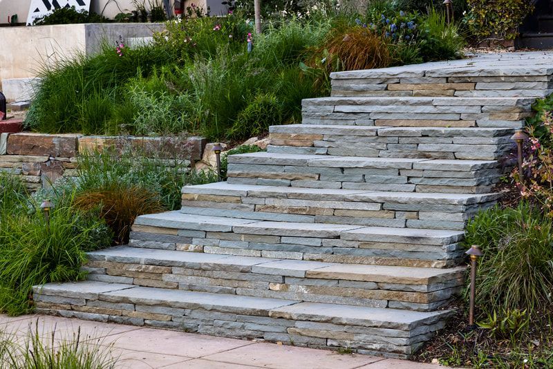 A set of stone stairs leading up to a house in a garden.