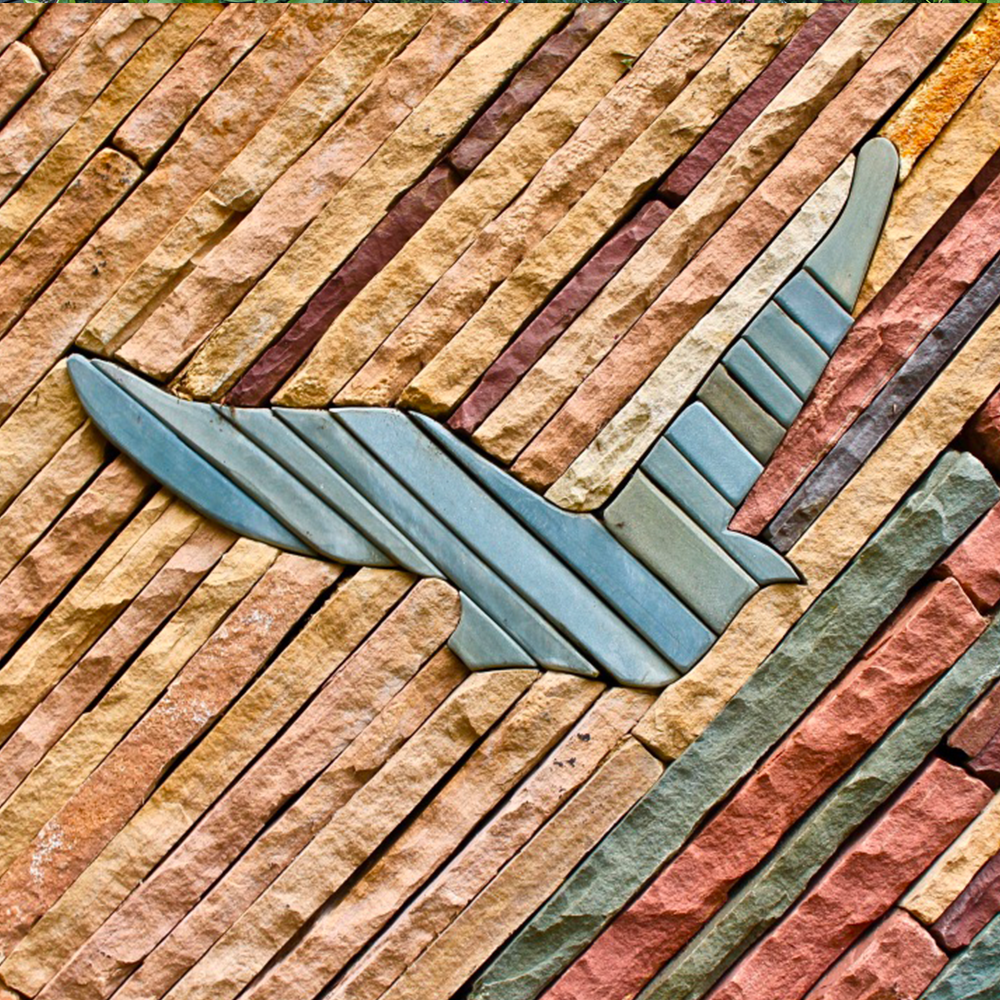 A row of bricks are stacked on top of each other in a garden.