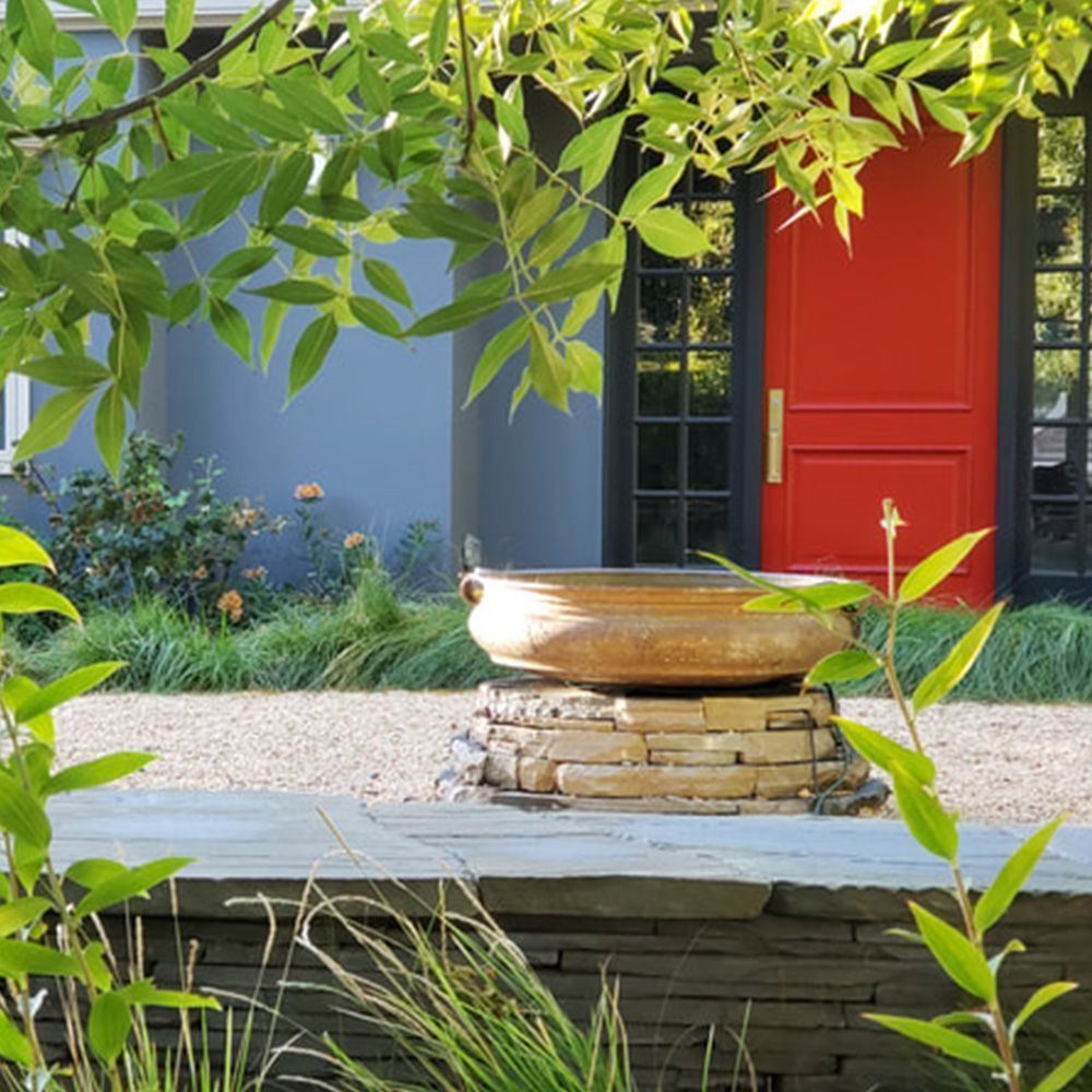 A red door is visible behind a stone wall