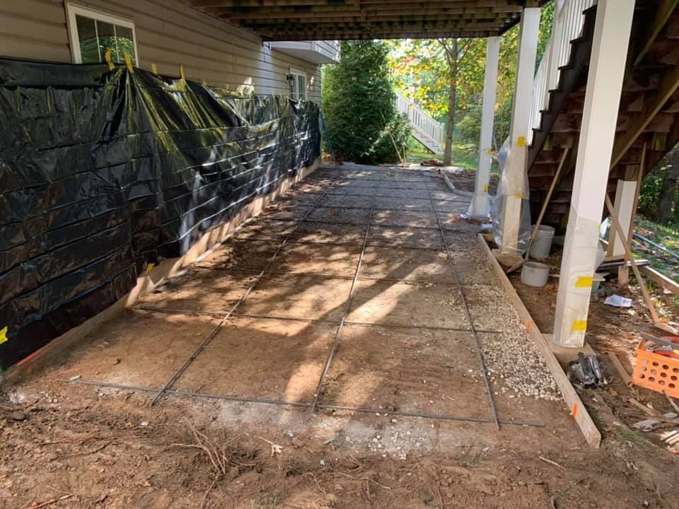 Concrete slab under a deck, with wire mesh in place; construction in progress.
