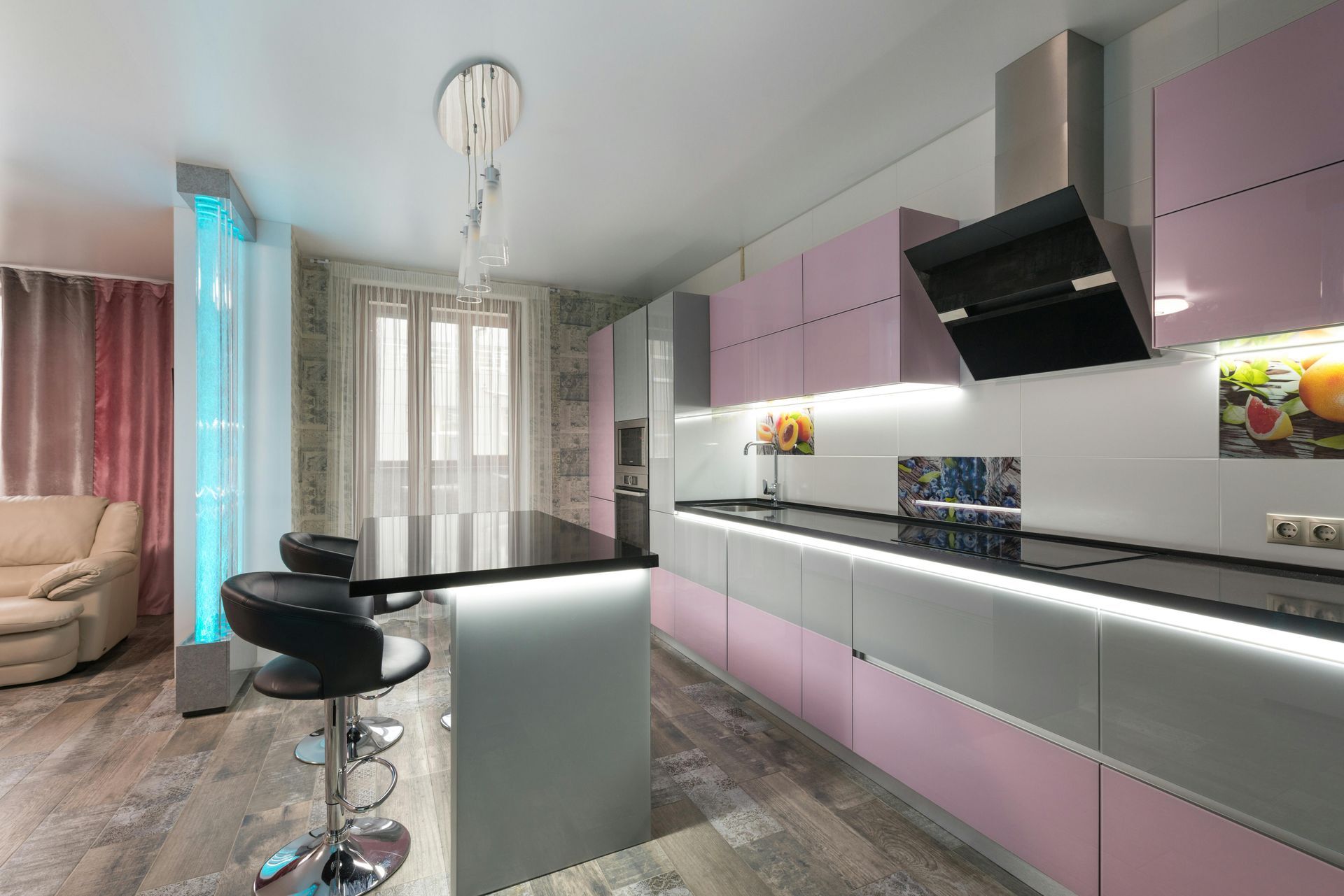 Modern pink-and-gray kitchen with island, bar stools, pendant light, and large window seating area