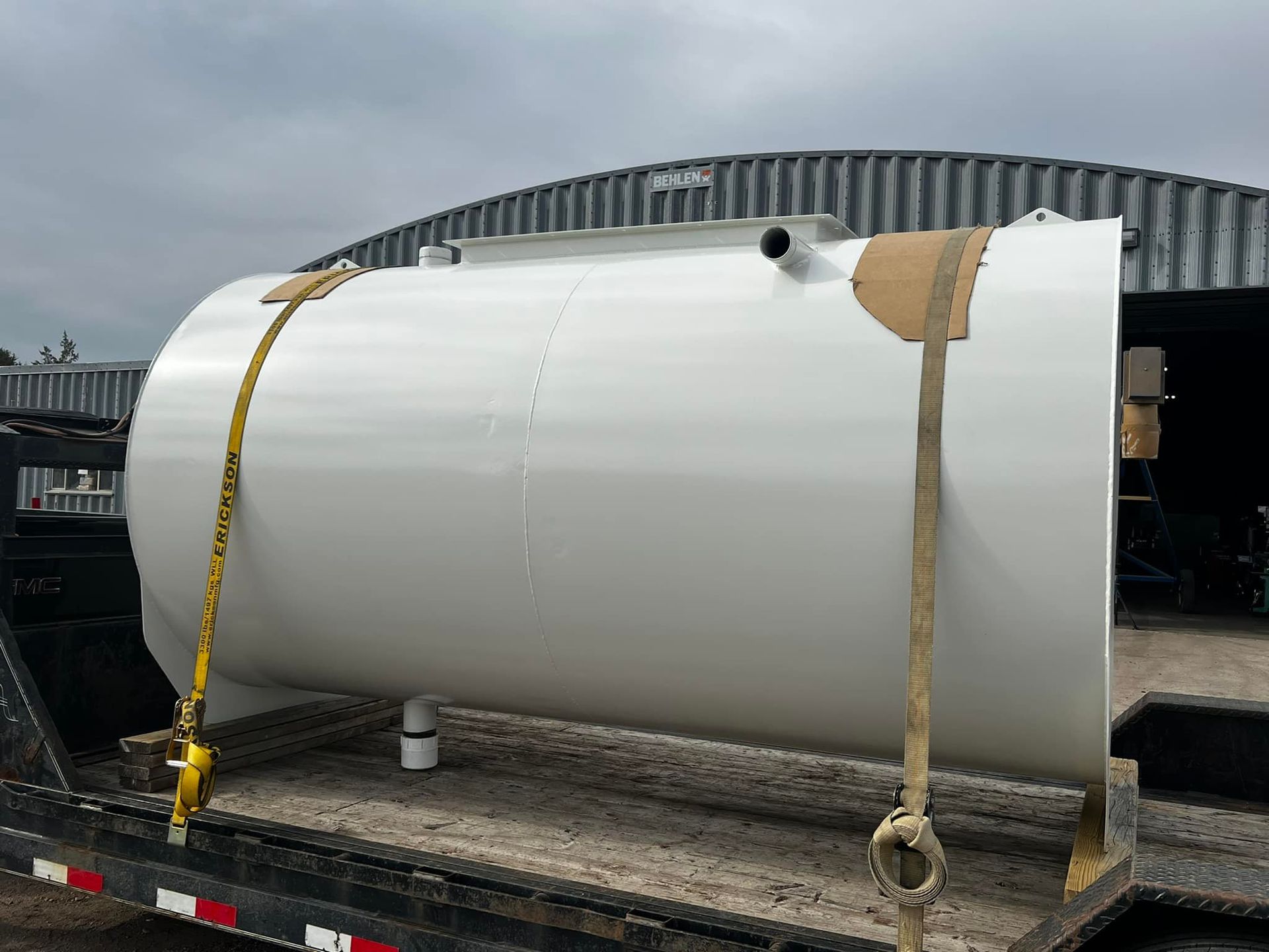 A large white tank is sitting on top of a trailer.