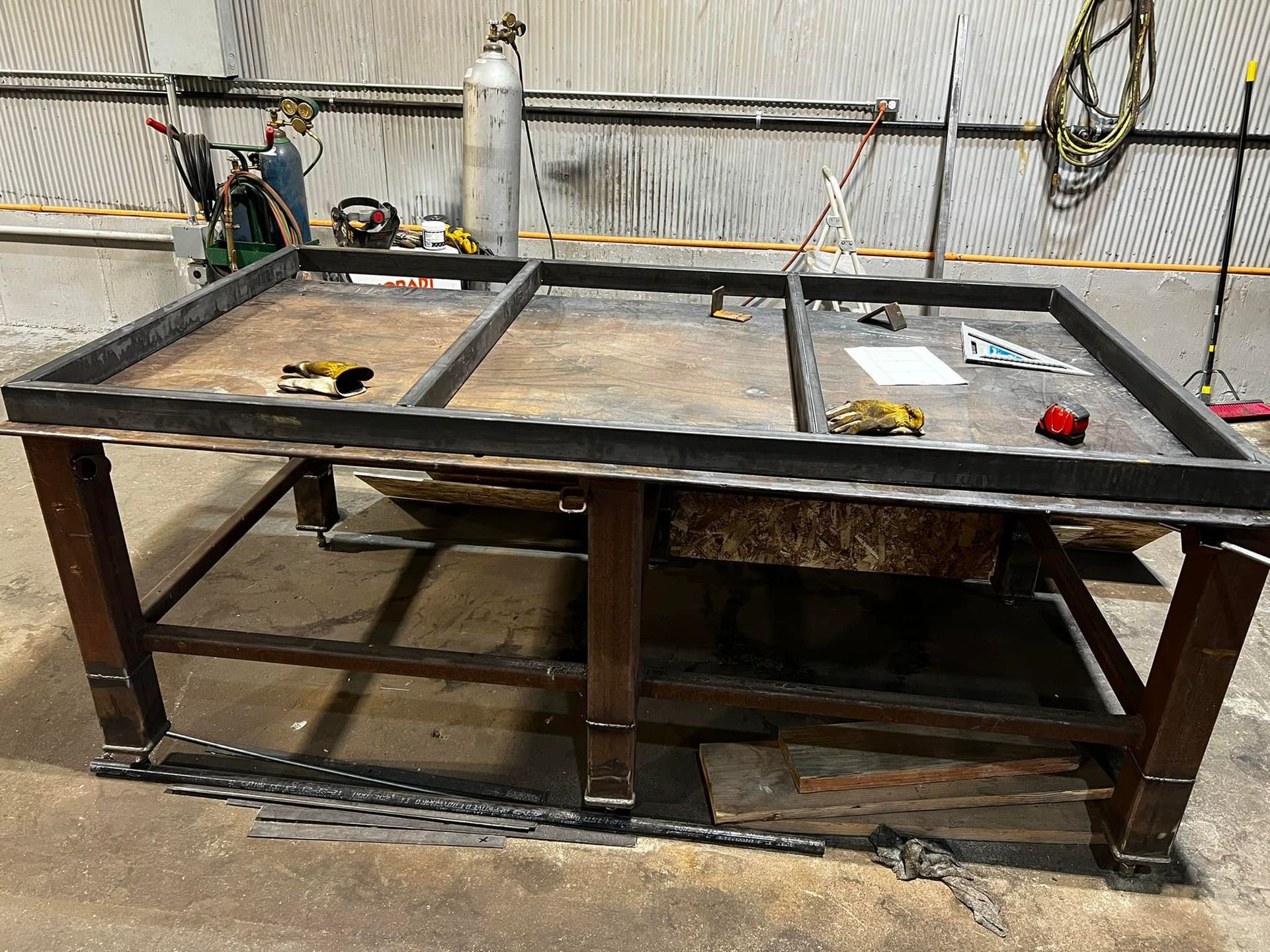A metal table with a wooden frame is sitting in a room.