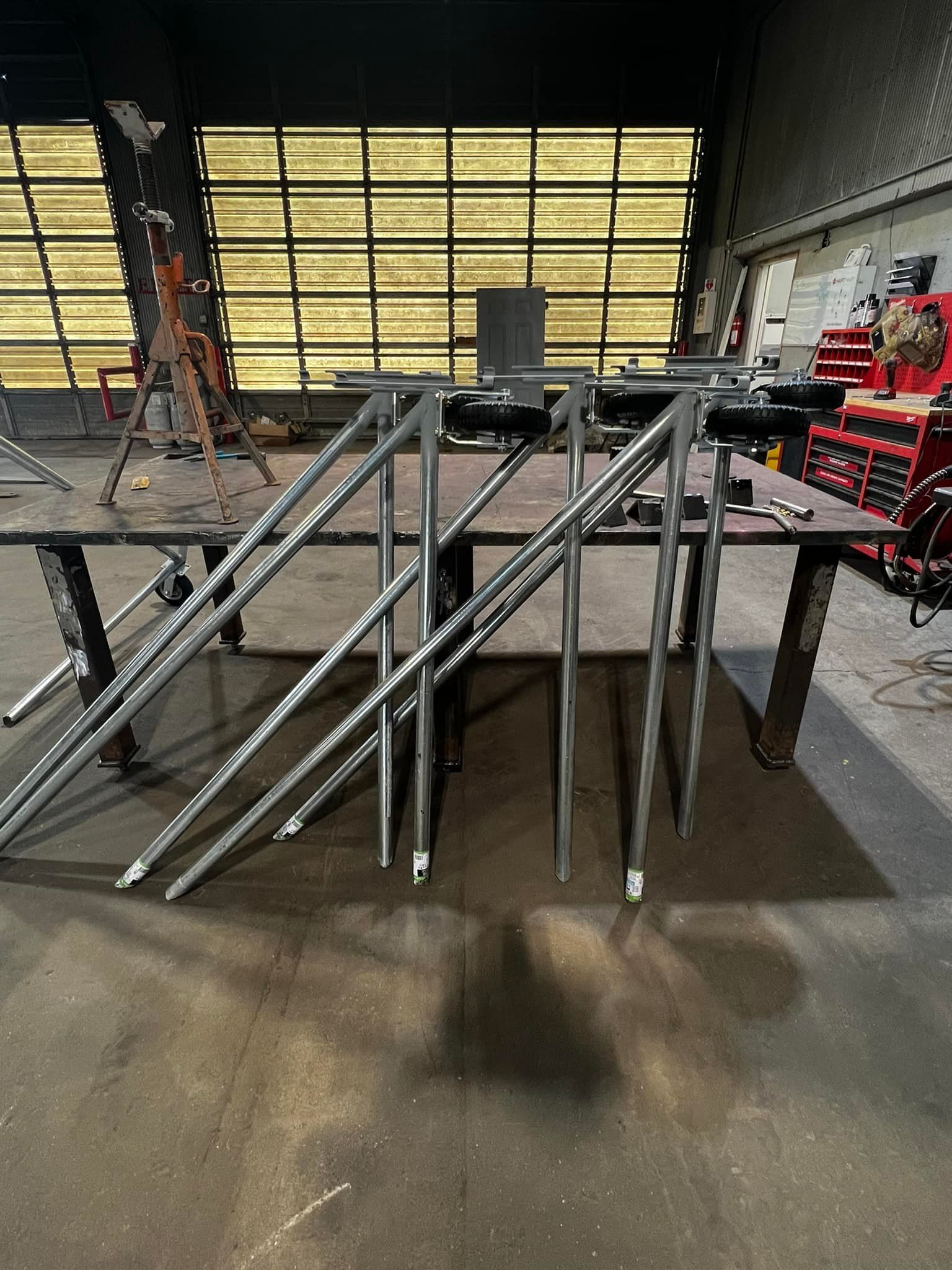 A bunch of metal pipes are sitting on top of a table in a warehouse.