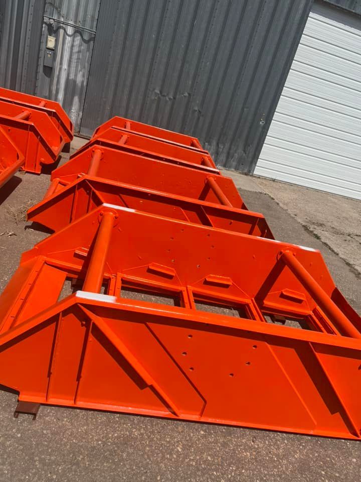 A bunch of orange pieces of metal are sitting on the ground