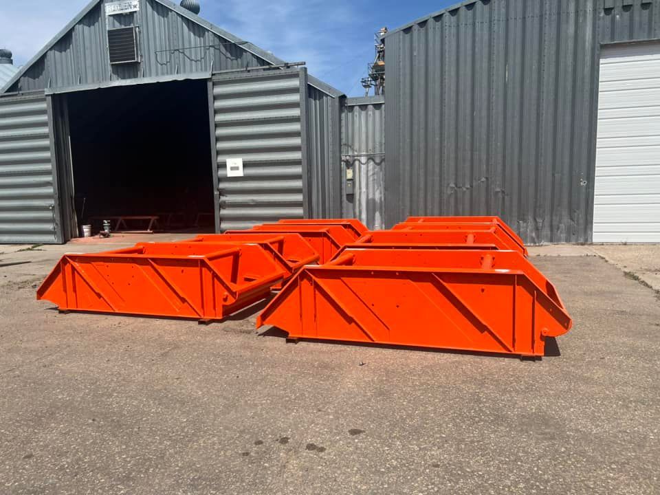 A bunch of orange bins are sitting in front of a building