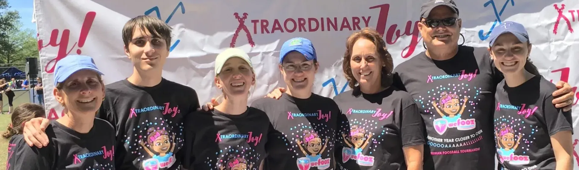 Group of people wearing matching shirts under a 