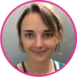 Woman with brown hair and nose ring smiles, framed in a pink circle.