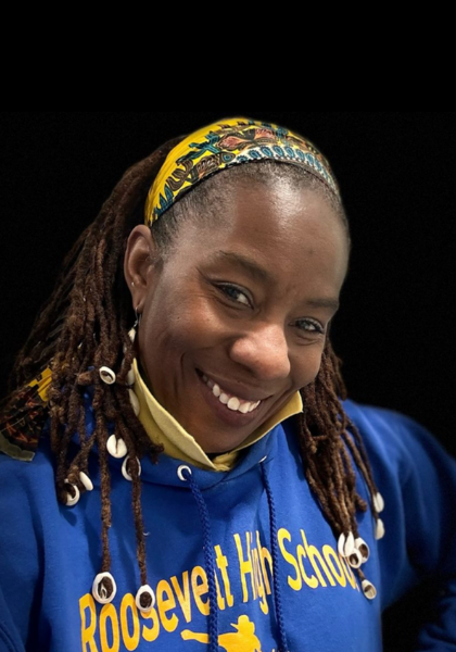 Smiling person in a blue Roosevelt School hoodie and colorful headband against a black background