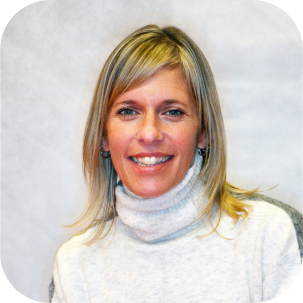 Portrait of a smiling woman in a white turtleneck against a light background