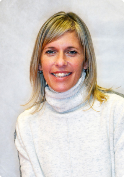 Smiling woman in a light gray turtleneck sweater against a plain background