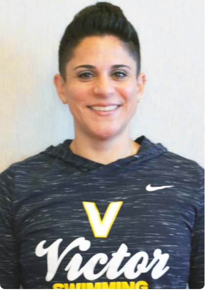 Person in a navy Victor hoodie, smiling against a plain light background.