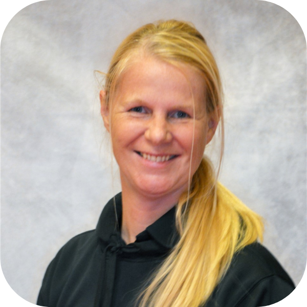 Smiling woman in a black collared shirt against a light gray backdrop