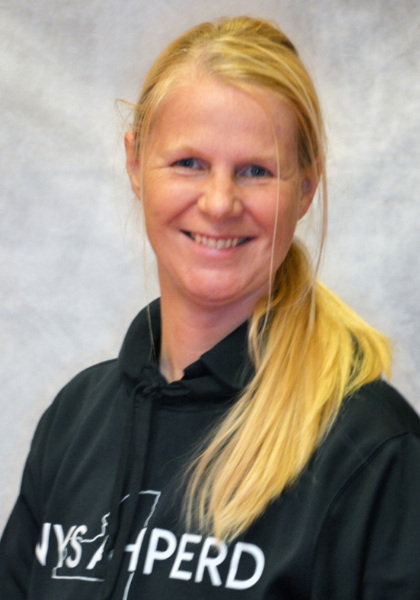 Smiling person in a black hoodie against a gray background