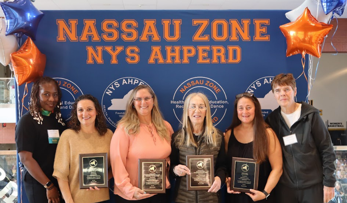 Students holding plaques in front of a blue “NASSAU ZONE NYS AHPERD” banner at an awards ceremony